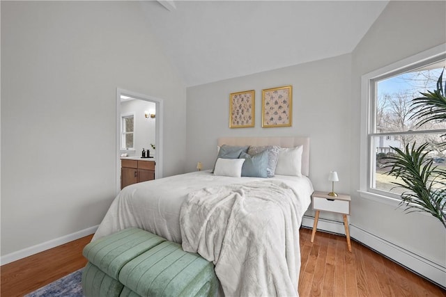 bedroom featuring baseboard heating, multiple windows, and lofted ceiling