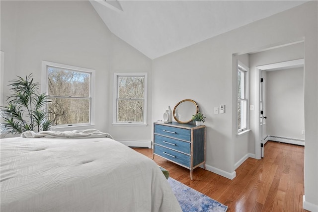 bedroom featuring wood finished floors, a baseboard radiator, baseboards, baseboard heating, and vaulted ceiling