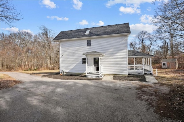 back of house with covered porch and driveway