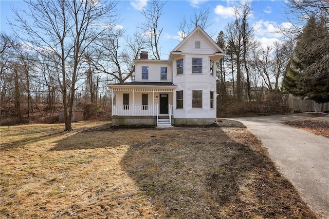 victorian home with covered porch and a chimney