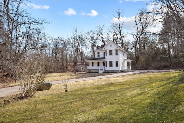 victorian home with a front lawn and a chimney