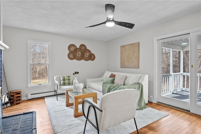 living room with a baseboard heating unit, wood finished floors, and ceiling fan