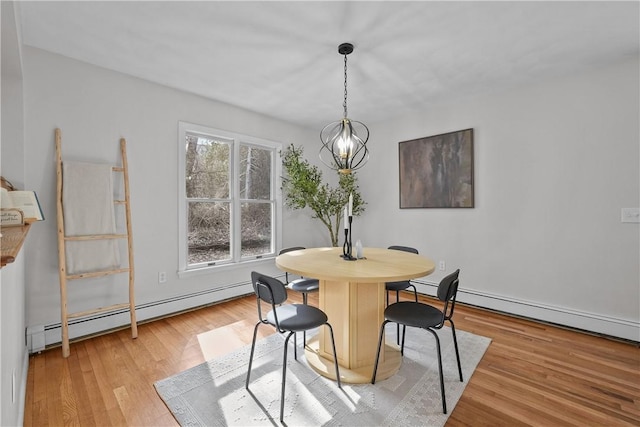 dining area featuring a chandelier, light wood-type flooring, and a baseboard radiator