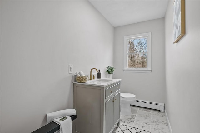 bathroom featuring toilet, marble finish floor, a baseboard heating unit, baseboards, and vanity