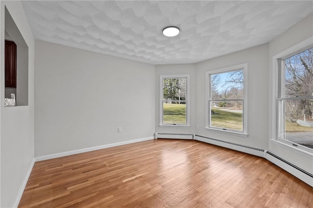 empty room featuring light wood finished floors and baseboards