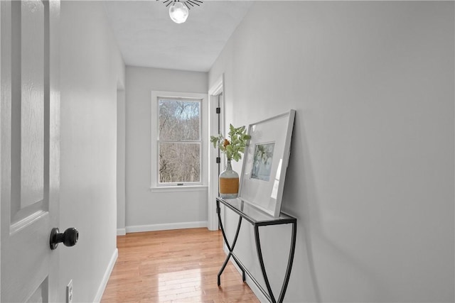 interior space featuring baseboards and light wood finished floors