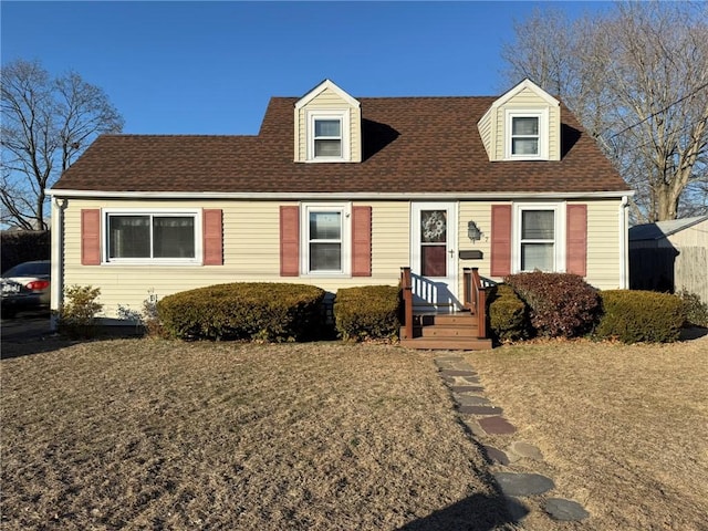 cape cod-style house featuring roof with shingles