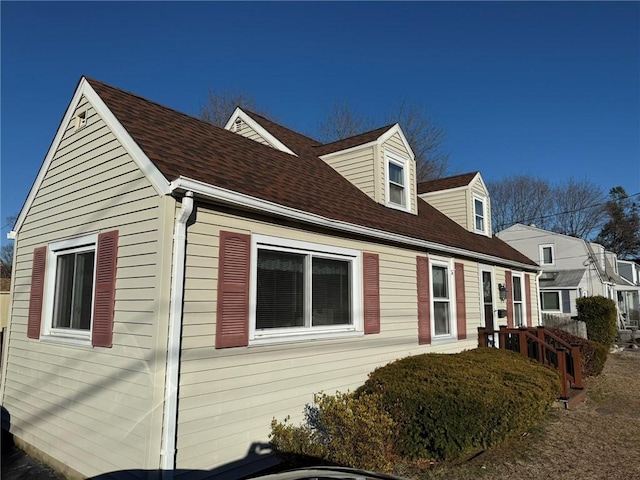 view of side of property featuring roof with shingles