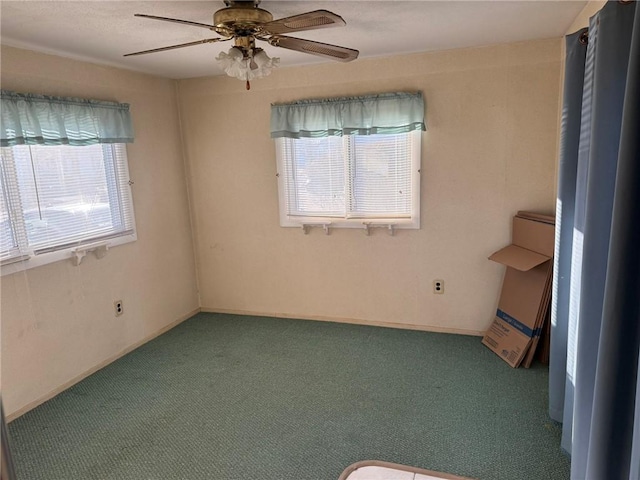 carpeted spare room with a ceiling fan