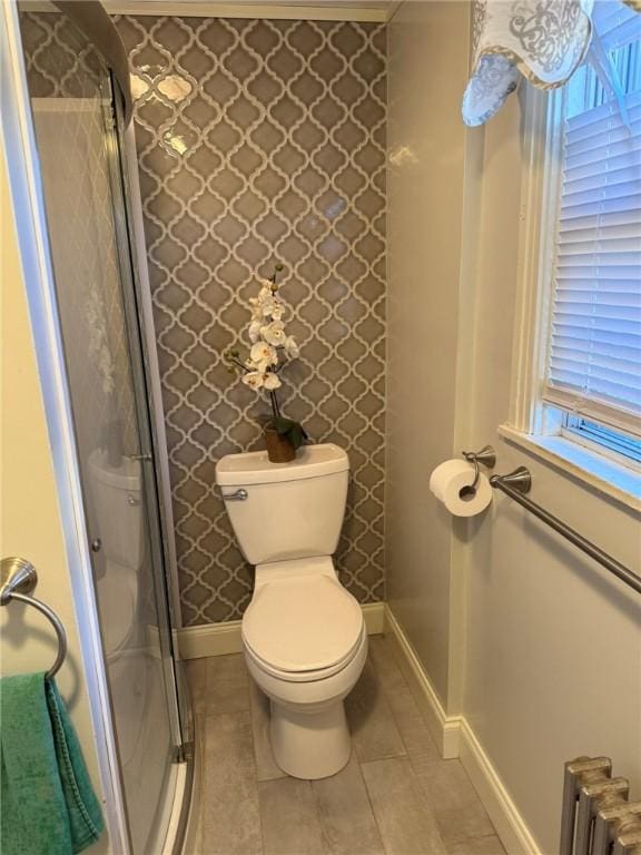 bathroom featuring baseboards, radiator, tile patterned flooring, and toilet