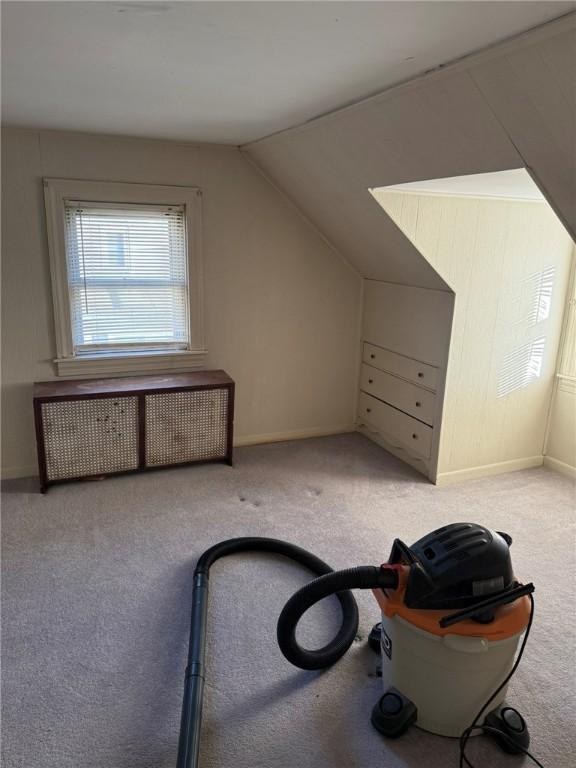 additional living space with vaulted ceiling, radiator heating unit, baseboards, and carpet floors