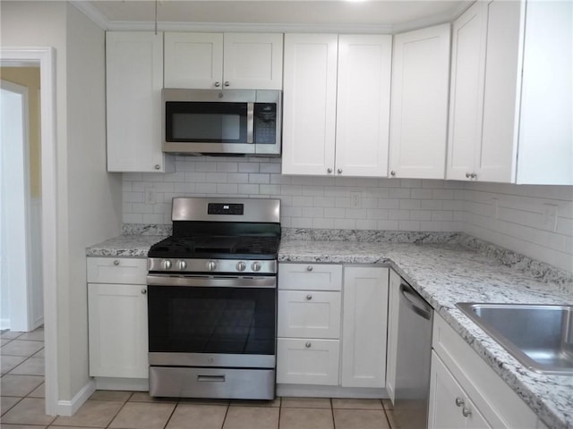 22 Kendall Ln, Warwick, RI 02888 - kitchen featuring white cabinetry, appliances with stainless steel finishes, light tile patterned floors, and tasteful backsplash