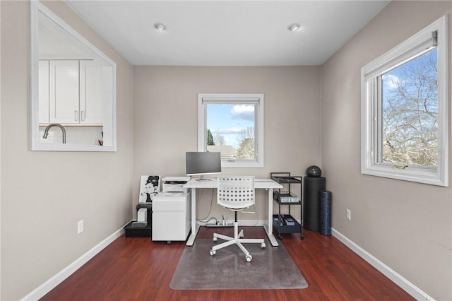 home office with plenty of natural light, baseboards, and dark wood-style flooring