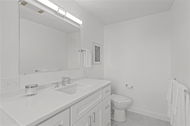 bathroom with baseboards, toilet, and vanity