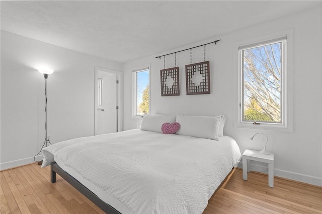 bedroom with baseboards and wood-type flooring