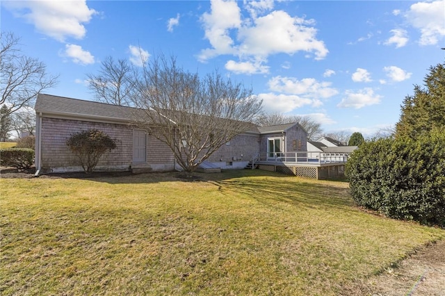 rear view of property with a yard and a deck