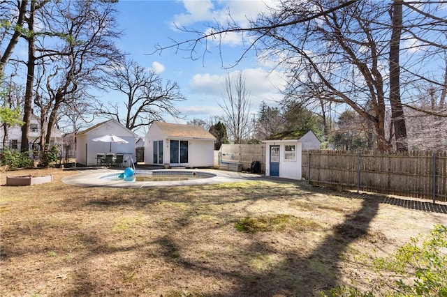 view of yard featuring a fenced in pool, a storage structure, a fenced backyard, an outdoor structure, and a patio