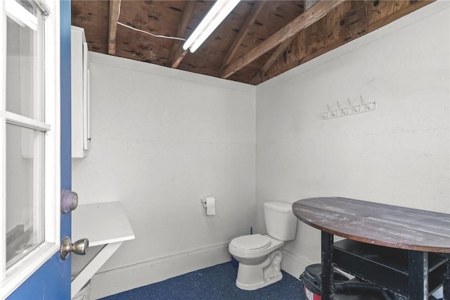 bathroom featuring toilet and baseboards