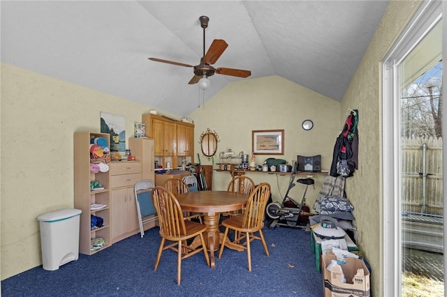 dining room with lofted ceiling, carpet, a textured wall, and ceiling fan