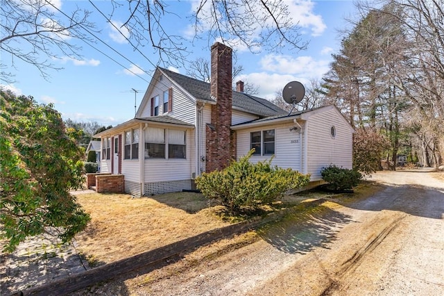 exterior space featuring dirt driveway and a chimney