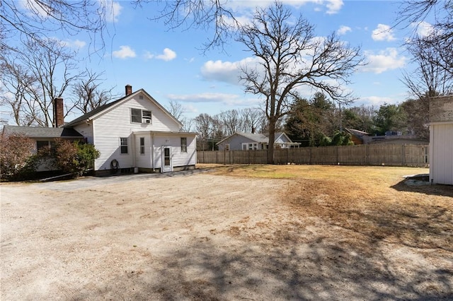 exterior space featuring fence and a chimney