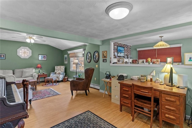 office area with a baseboard heating unit, baseboards, vaulted ceiling, wood finished floors, and a ceiling fan