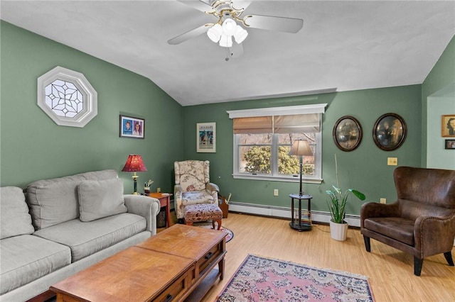 living area featuring lofted ceiling, a baseboard heating unit, wood finished floors, baseboards, and ceiling fan