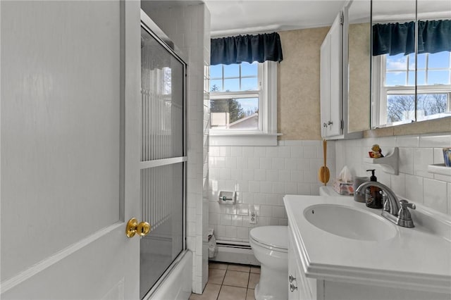 bathroom featuring vanity, tile patterned floors, toilet, tile walls, and combined bath / shower with glass door