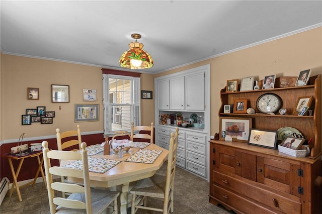 dining area featuring a baseboard heating unit, crown molding, and baseboards