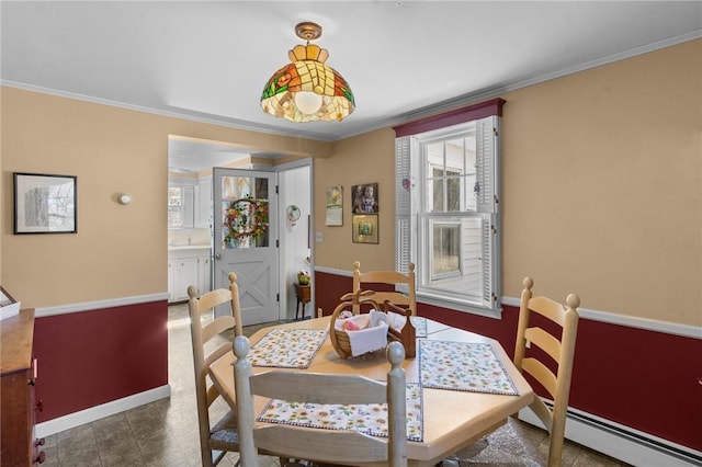 dining space with a wealth of natural light, baseboard heating, and ornamental molding