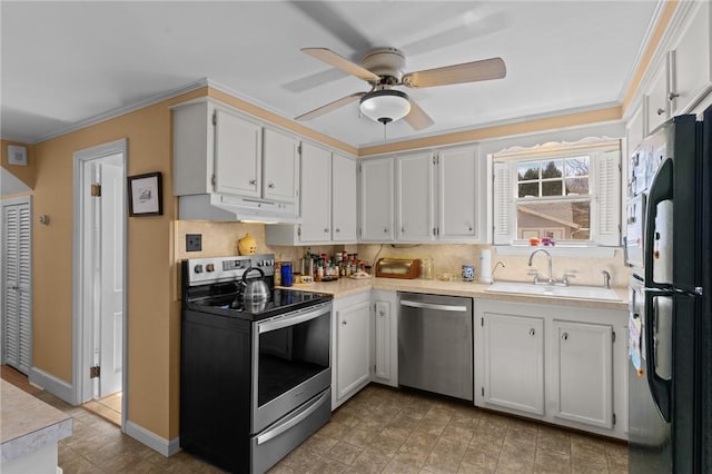 kitchen featuring under cabinet range hood, appliances with stainless steel finishes, light countertops, and a sink