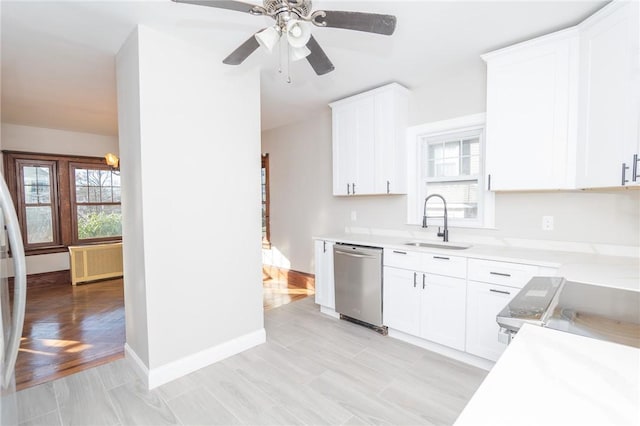 kitchen featuring a healthy amount of sunlight, radiator, light countertops, appliances with stainless steel finishes, and a sink