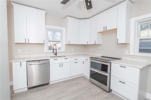 kitchen featuring a sink, light countertops, plenty of natural light, and stainless steel appliances