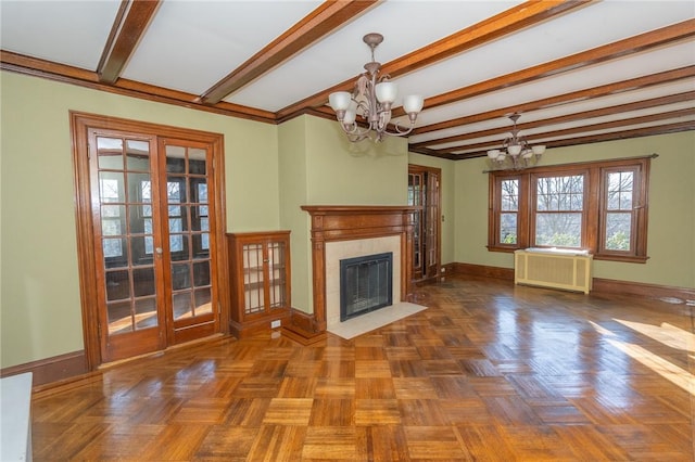 unfurnished living room with beamed ceiling, radiator heating unit, an inviting chandelier, a fireplace, and baseboards