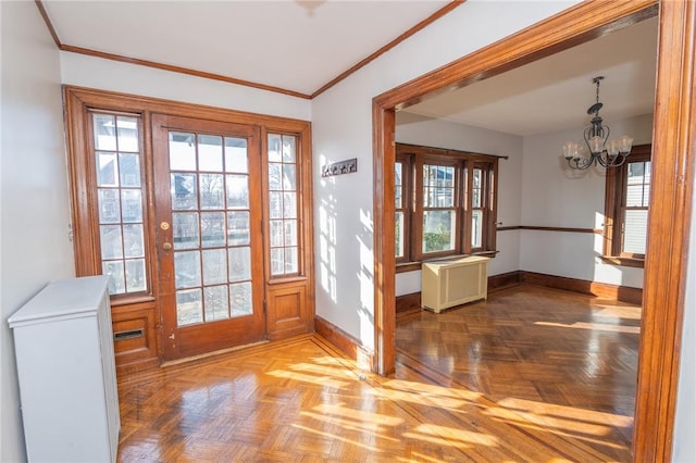 doorway to outside featuring a notable chandelier, radiator, baseboards, and ornamental molding