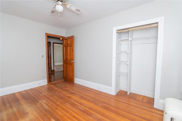 unfurnished bedroom with baseboards, a ceiling fan, and hardwood / wood-style flooring