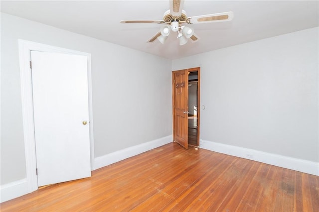 spare room featuring a ceiling fan, baseboards, and wood-type flooring