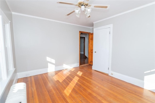 unfurnished room featuring baseboards, radiator heating unit, ornamental molding, wood finished floors, and a ceiling fan