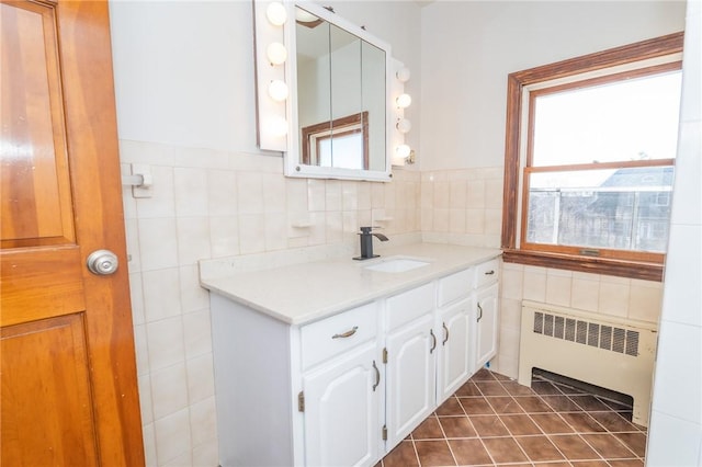 bathroom featuring vanity, tile walls, radiator, and a wealth of natural light