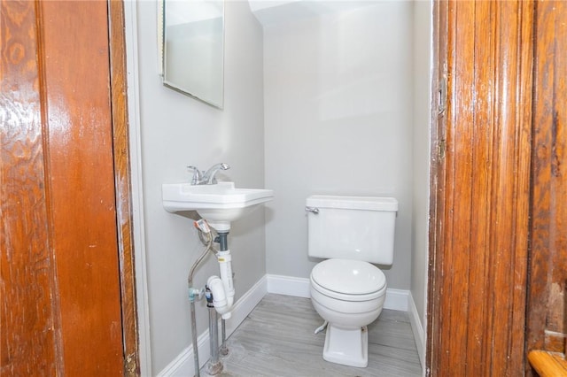 bathroom with baseboards and toilet