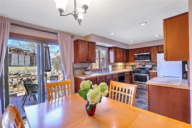 kitchen with a sink, stainless steel appliances, tasteful backsplash, and light countertops