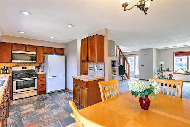 kitchen featuring decorative backsplash, light countertops, brown cabinetry, and stainless steel appliances