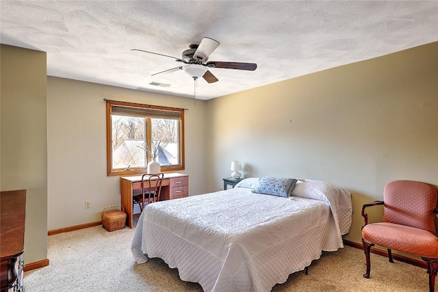 carpeted bedroom featuring ceiling fan, visible vents, baseboards, and a textured ceiling