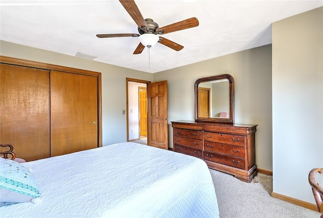 carpeted bedroom featuring a closet, ceiling fan, and baseboards