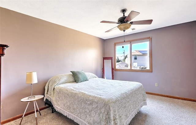 bedroom featuring baseboards, light colored carpet, and a ceiling fan