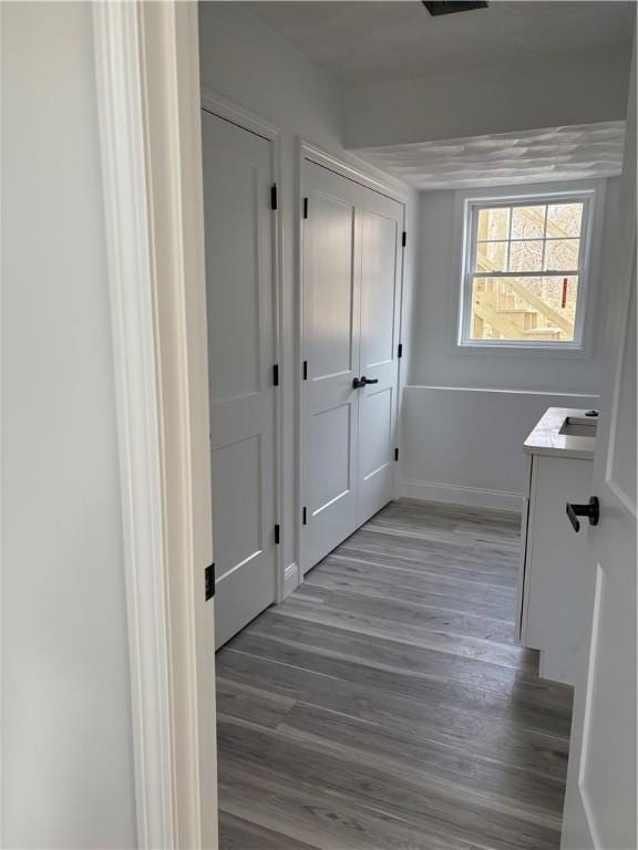 hallway featuring baseboards and wood finished floors