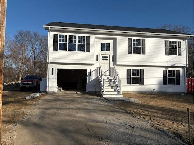 raised ranch featuring aphalt driveway and a garage