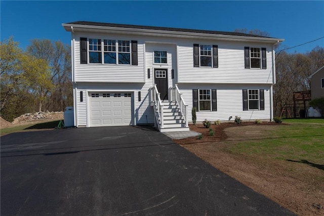 raised ranch with a garage and aphalt driveway