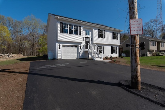 split foyer home with aphalt driveway and a garage