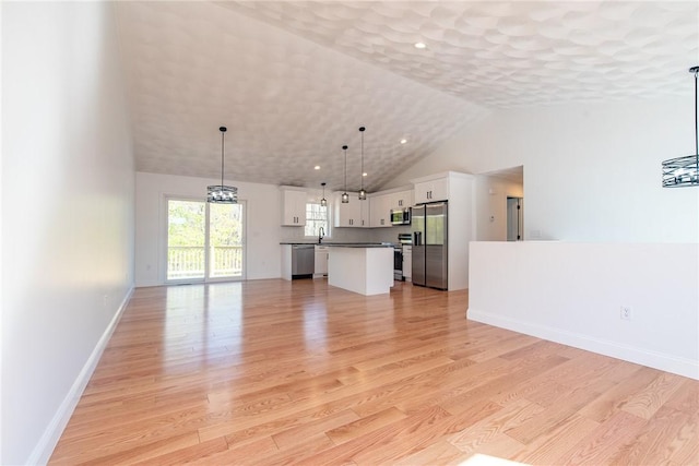 unfurnished living room featuring lofted ceiling, a sink, baseboards, light wood-type flooring, and recessed lighting